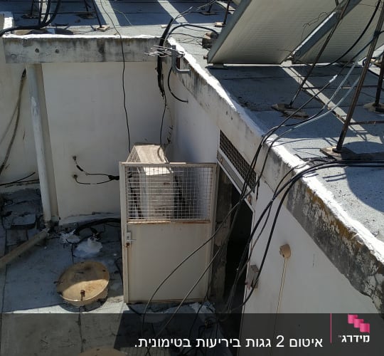 גג עם לוחות סולאריים, כבלים ומכסה ביוב